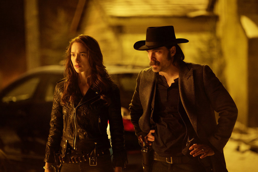 WYNONNA EARP -- "Walk After Midnight" Episode 107 -- Pictured: (l-r) Melanie Scrofano as Wynonna Earp, Tim Rozon as Doc Holliday -- (Photo by: Michelle Faye/Syfy/Wynonna Earp Productions)